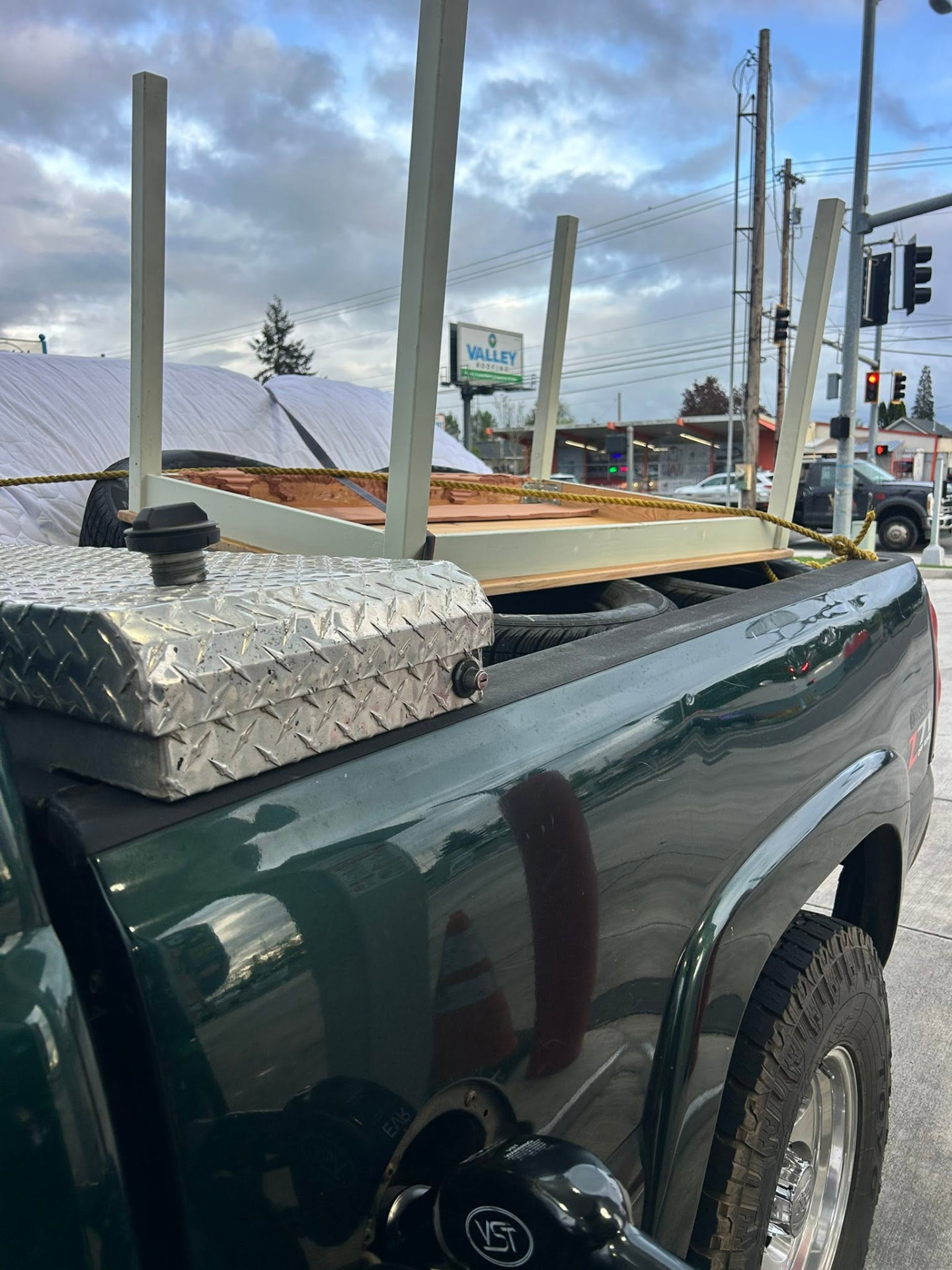 Pickup truck loaded with a mattress, table and lumber ready for disposal